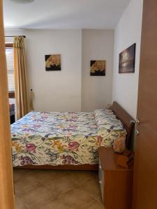 ブラッチャーノにあるLa Rosa del lagoのベッドルーム1室(ベッド1台付)が備わります。壁に2枚の写真が飾られています。