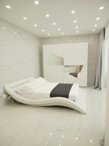 a white bedroom with a large bed in a room at Elegant basement Suite in Orosei