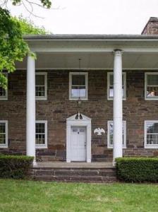 a brick house with a white door and columns at Weaverling House- Historic Stay in Smalltown America in Everett