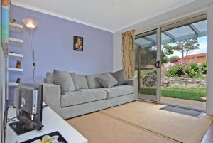 sala de estar con sofá y TV en Marazul BEST DEAL - Stone Bathtub, WIFI, Functional - Mandarins and lemons when available, en Vincentia