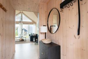 Zimmer mit einem Spiegel und einem Tisch mit einer Lampe in der Unterkunft Haukland beach panorama in Offersøya