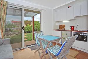 a kitchen with a table and two chairs and a table at Marazul BEST DEAL - Stone Bathtub, WIFI, Functional - Mandarins and lemons when available in Vincentia