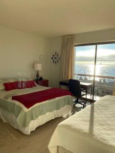 um quarto com uma cama e vista para o oceano em Hermoso departamento frente al mar, Viña del Mar Reservar con más de un día de anticipación em Viña del Mar