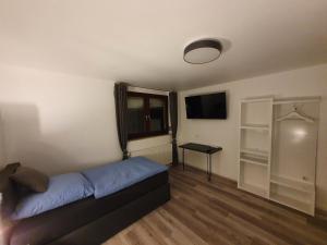 a room with a bed and a tv and a table at Haus Fasanerie in Fulda