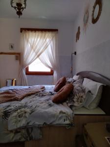1 cama con almohadas en un dormitorio con ventana en The Vintage House Zlatar, en Nova Varoš