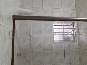 a shower in a bathroom with a window at Good Vibes in Praia Grande