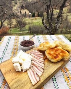 una tabla de cortar con carne y queso sobre una mesa en The Vintage House Zlatar, en Nova Varoš