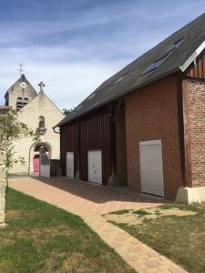 un bâtiment en briques avec trois portes de garage et une église dans l'établissement Cottage chaleureux situé en pleine nature !, 