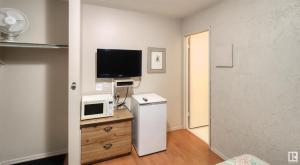 a room with a refrigerator and a tv and a microwave at Kings Court Motel in Cold Lake