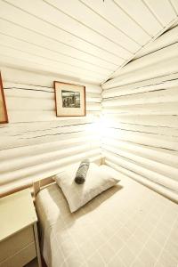 1 dormitorio con 1 cama en una pared de madera en Muhu cabin Aasa en Igaküla