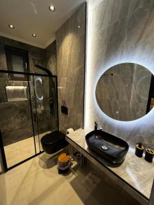a bathroom with a sink and a large mirror at City Compass Luxury Suites in Rhodes Town