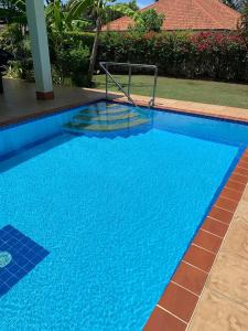 a swimming pool with blue water in a yard at Mountain View Villa in Sam Roi Yot