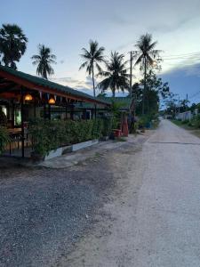 an empty street with palm trees and a building at Mountain View Villa in Sam Roi Yot