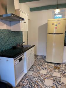 una cucina con frigorifero e pavimento piastrellato di Völgyhíd Vintage Apartman a Pusztaszemes