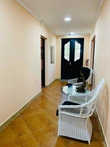 a hallway with chairs and a table and a black door at Villa Gardenia Ureki in Ureki