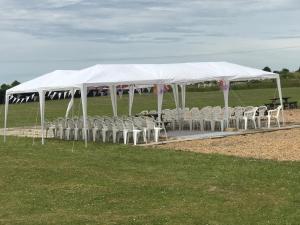 a group of chairs under a white tent at Coach house hotel in Royston