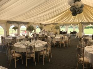 a tent with tables and chairs in a room at Coach house hotel in Royston