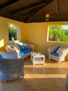 a living room with wicker chairs and a table at Maxi Villa Antiope Argonauti Resort in Marina di Pisticci