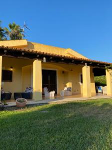 una casa con porche con sofás y patio en Maxi Villa Antiope Argonauti Resort en Marina di Pisticci