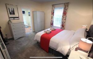 a bedroom with a large bed with a red blanket at Ballyconnelly Cottages, Galgorm area in Cullybackey