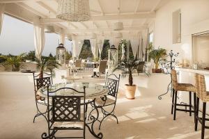 a room with a table and chairs and potted plants at Tenuta Del Poggio Antico in Ischia