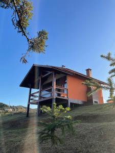 a house on a hill with a tree at Chalés Vale das Araucárias Bairro dos Onças in Gonçalves