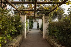a walkway in a garden with a pergola at Tenuta Del Poggio Antico in Ischia