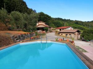 a large blue swimming pool in front of a house at Villa Armonia in Borgo a Mozzano