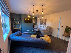a living room with a blue couch in a room at Modern three bedroom home, Hoyland, Barnsley in Hoyland Nether