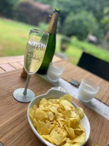 La Bruyère的住宿－La Cabane Enchantée - Votre Pause Arborée，桌上放一碗薯条和一杯葡萄酒