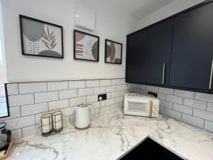 a kitchen with a counter top with a microwave at Modern three bedroom home, Hoyland, Barnsley in Hoyland Nether