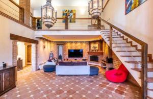 uma grande sala de estar com uma escada e um sofá em Villas Cozyinns em Cártama