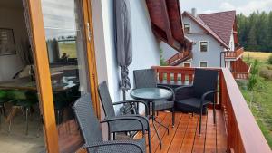 einen Balkon mit Stühlen und einem Tisch auf einem Haus in der Unterkunft APARTMáN POD SMRČINOU in Vaclavov u Bruntalu