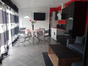 a living room with a table and chairs and a kitchen at Villa Piscine in Montady