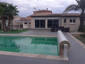 a swimming pool in front of a house at Villa Piscine in Montady