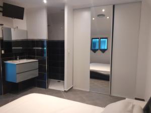 a bathroom with a bed and a sink and a mirror at Villa Piscine in Montady