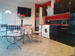 a kitchen with a table and chairs and a washing machine at Villa Piscine in Montady