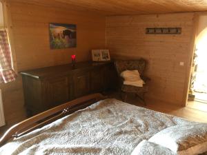 ein Schlafzimmer mit einem Bett und einem Stuhl in einem Zimmer in der Unterkunft Pfaffensteghof in Rickenbach