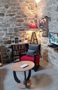 een woonkamer met een rode stoel en een tafel bij La Sabotiere in Pluméliau