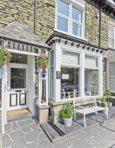 una casa con una panchina di fronte a un edificio di Broadlands Windermere a Windermere