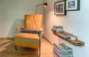 an orange chair sitting in a room with books at 1 Bedroom Beautiful Home In Boekelo in Boekelo