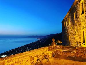 a view of the ocean from a castle at night at Residenza Matilde in Fiumefreddo Bruzio