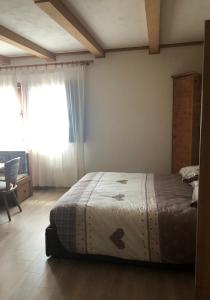 - une chambre avec un lit, une chaise et une fenêtre dans l'établissement Paradise Dolomiti flat, à Falcade