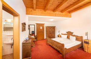 a bedroom with a large bed and a bathroom at Hotel Traube in Fliess