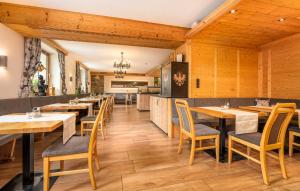 um restaurante com paredes e mesas e cadeiras de madeira em Hotel Traube em Fliess