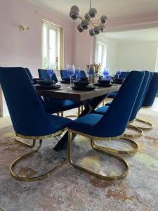 a dining room with a table with blue chairs at Luxury 4-5 Bed Home with Games Room and Balcony in Newtown