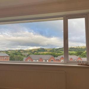 a window in a room with a view of houses at Luxury 4-5 Bed Home with Games Room and Balcony in Newtown