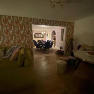 a living room with a couch and a table and chairs at Luxury 4-5 Bed Home with Games Room and Balcony in Newtown