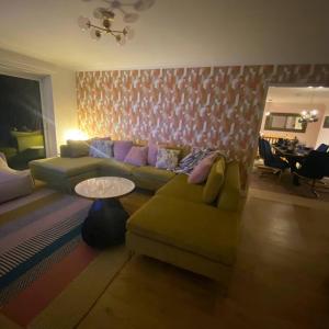 a living room with a couch and a table at Luxury 4-5 Bed Home with Games Room and Balcony in Newtown +27 photos