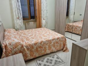 a bedroom with two beds and a mirror at La Casa di Dedè in Sale